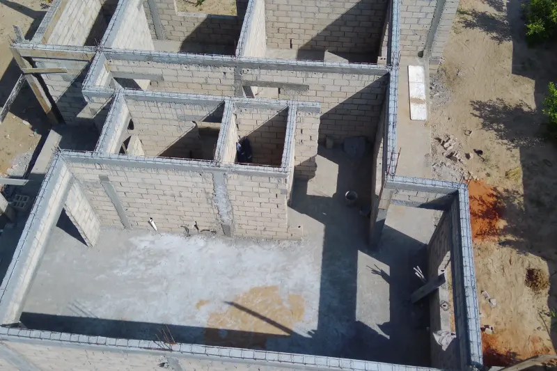 Detalhe aéreo da execução de alvenaria e vigas de betão na obra