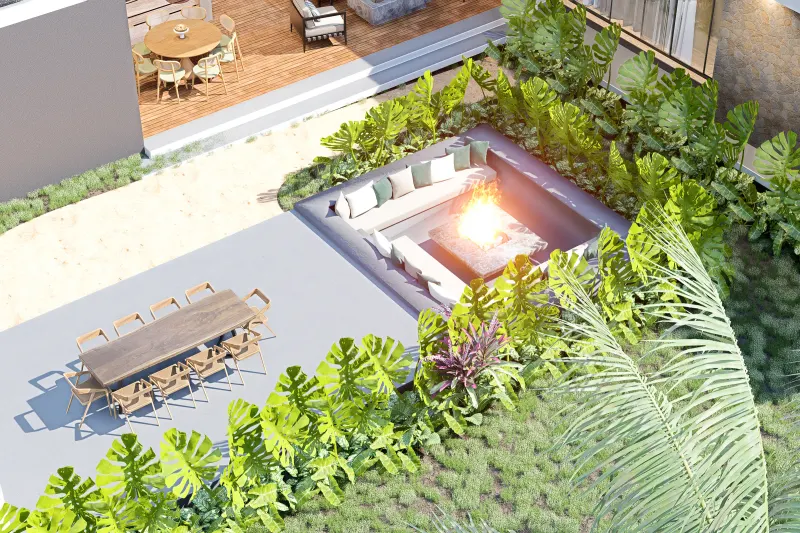 Enquadramento aéreo da sala de estar exterior com fogueira e mesa comprida.
