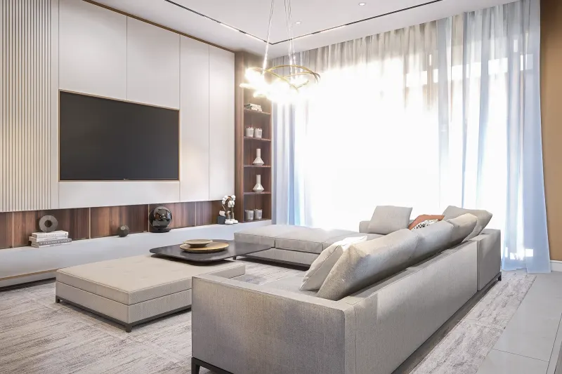 Sala de estar espaçosa com sofá em L cinzento, otomana e móvel de TV