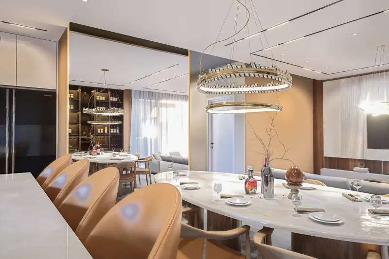Perspetiva da sala de jantar com mesa de mármore e banquetas em primeiro plano