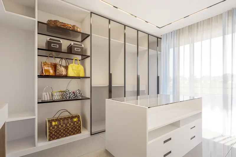 Closet sofisticado com ilha central, gaveteiro e prateleiras para malas e bolsas