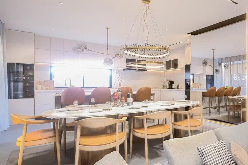Sala de jantar e cozinha clara com lustre duplo e mesa de mármore