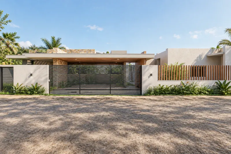 Portão de entrada ripado e muro perimetral com acesso em terra batida